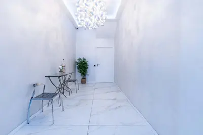 a hallway with a table and chairs and a chandelier at Bliss Triplex - Hyper Centre - Sauna - BBQ - Jacuzzi - LRACANNES in Cannes