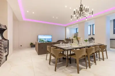 a dining room with a long table and chairs at Bliss Triplex - Hyper Centre - Sauna - BBQ - Jacuzzi - LRACANNES in Cannes