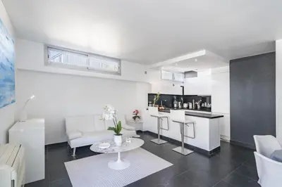 a living room with a table and a kitchen at Rooftop la Croisette in Cannes
