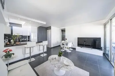 a large living room with a table and a tv at Rooftop la Croisette in Cannes