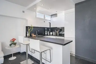 a kitchen with a black and white counter and stools at Rooftop la Croisette in Cannes