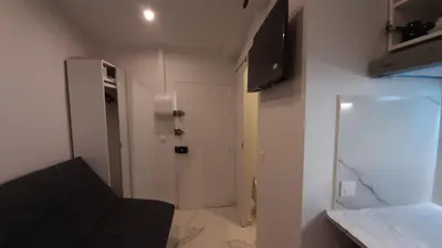 a small room with a black couch and a white door at Winter Palace Beauséjour in Cannes