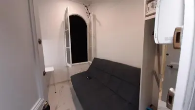 a small room with a couch and a window at Winter Palace Beauséjour in Cannes
