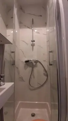 a bathroom with a shower with a glass door at Winter Palace Beauséjour in Cannes