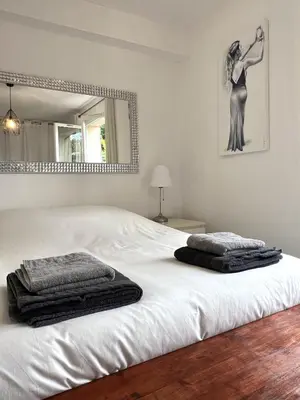 a bedroom with a large white bed with a mirror at Maison de charme idéalement située in Cannes