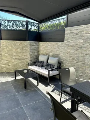 a patio with a bench and a table and chairs at Maison de charme idéalement située in Cannes