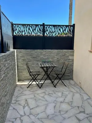 a patio with two chairs and a table on a wall at Maison de charme idéalement située in Cannes