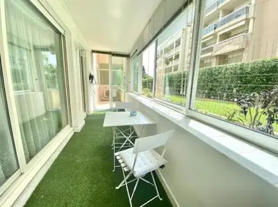 a balcony with a table and chairs and windows at Cannes Résidence Passy avec Piscine in Cannes