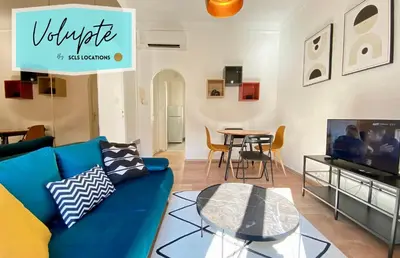 a living room with a blue couch and a table at Volupté By SCLS Locations in Cannes