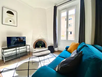 a living room with a blue couch and a fireplace at Volupté By SCLS Locations in Cannes