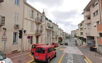 a red car driving down a city street with buildings at Volupté By SCLS Locations in Cannes