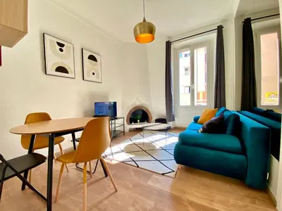 a living room with a blue couch and a table at Volupté By SCLS Locations in Cannes