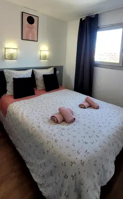 a bedroom with a large bed with two pillows on it at Appartement proche de la plage in Cannes