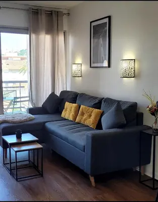 a blue couch in a living room with a window at Appartement proche de la plage in Cannes