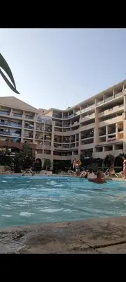 a large apartment building with people swimming in a pool at Appartement proche de la plage in Cannes