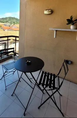 a table and two chairs sitting on a balcony at Appartement proche de la plage in Cannes