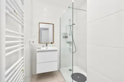 a white bathroom with a sink and a mirror at Croisette et Plages - Lumineux deux pièces - FW in Cannes