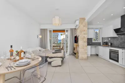 a kitchen and a living room with a table at Croisette et Plages - Lumineux deux pièces - FW in Cannes