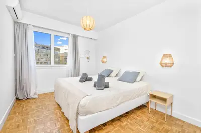 a white bedroom with a large bed and a window at Croisette et Plages - Lumineux deux pièces - FW in Cannes