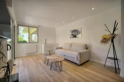 a living room with a couch and a table at Le Greg - Terrasse - Parking - VCA in Cannes