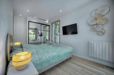 a bedroom with a bed and a television on the wall at Le Greg - Terrasse - Parking - VCA in Cannes