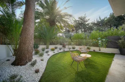 a garden with a table and chairs and a tree at Le Greg - Terrasse - Parking - VCA in Cannes