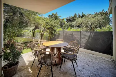 a patio with a table and chairs and a fence at Le Greg - Terrasse - Parking - VCA in Cannes