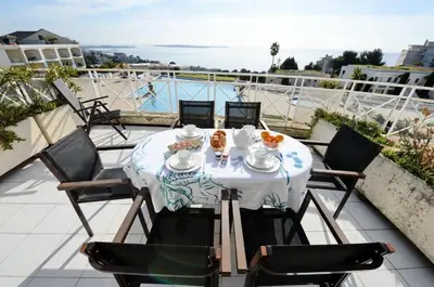 a table on a balcony with a view of a boat at Résidence Cannes Villa Francia - maeva Home - Appartement 2 pièces 5 personnes - Prestige MAE-2341 in Cannes