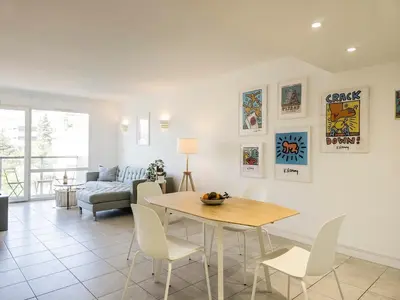 a living room with a table and chairs and a couch at A022 Chic Cannes Flat Balcony Parking in Cannes