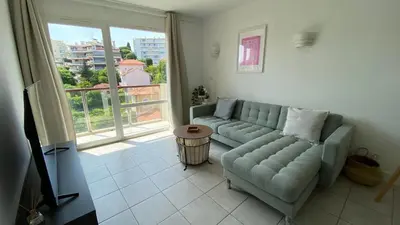 a living room with a couch and a large window at A022 Chic Cannes Flat Balcony Parking in Cannes