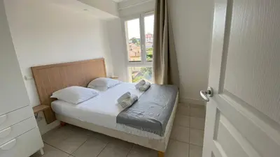 a small bedroom with a bed with a window at A022 Chic Cannes Flat Balcony Parking in Cannes