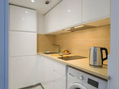 a kitchen with white cabinets and a washer at A022 Chic Cannes Flat Balcony Parking in Cannes