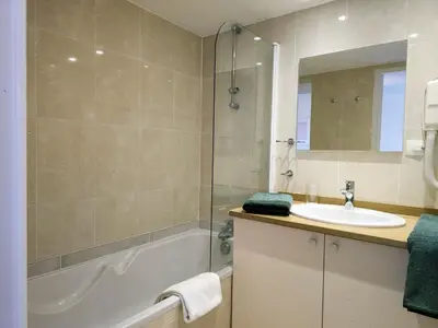 a bathroom with a tub and a sink and a mirror at A022 Chic Cannes Flat Balcony Parking in Cannes