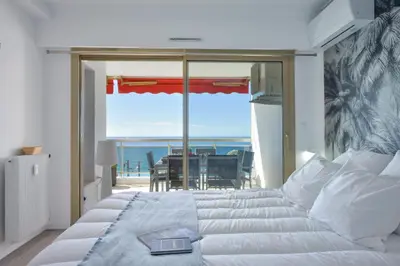 a bedroom with a bed with a view of the ocean at 2-Br sea view private parking walk to beaches in Cannes