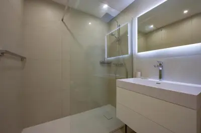 a white bathroom with a sink and a shower at 2-Br sea view private parking walk to beaches in Cannes