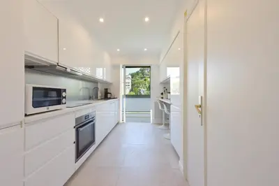 a kitchen with white appliances and a hallway at 2-Br sea view private parking walk to beaches in Cannes