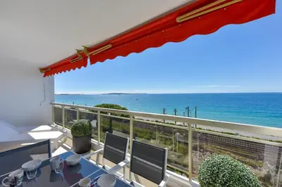 a balcony with a view of the ocean at 2-Br sea view private parking walk to beaches in Cannes