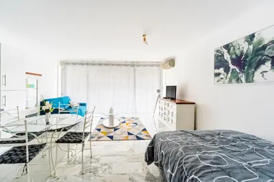 a bedroom with a table and a dining room at Grand studio centre-ville cannes aperçu mer in Cannes