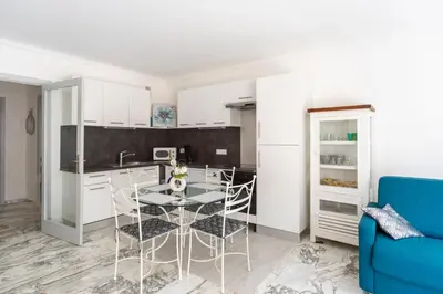 a kitchen and dining room with a table and chairs at Grand studio centre-ville cannes aperçu mer in Cannes