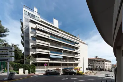 a large white building with cars parked in front of it at Grand studio centre-ville cannes aperçu mer in Cannes