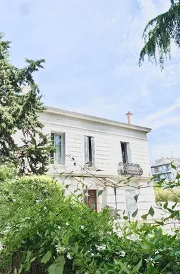 a white house with trees in front of it at Appartement Cosy in Le Cannet