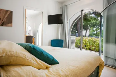 a bedroom with a bed with a television on the wall at Superbe Villa-Appartement sur la Croisette avec grande terrasse in Cannes