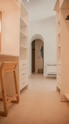 a kitchen with white cabinets and a wooden table at Superbe Villa-Appartement sur la Croisette avec grande terrasse in Cannes