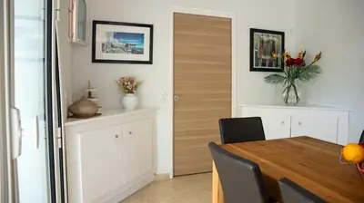 a dining room with a table and a vase of flowers at Superbe Villa-Appartement sur la Croisette avec grande terrasse in Cannes