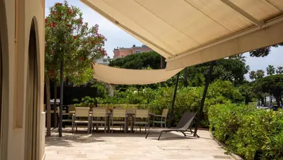a patio with a table and chairs and an umbrella at Superbe Villa-Appartement sur la Croisette avec grande terrasse in Cannes