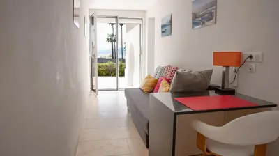 a living room with a couch and a desk with a chair at Superbe Villa-Appartement sur la Croisette avec grande terrasse in Cannes