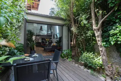 a patio with a table and chairs on a deck at Villa Le Loft by Festif Azur 4-Star 200m2 House with Garden, 5-Min Walk to Palais des Festivals and Beaches in Cannes