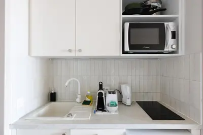 a kitchen counter with a sink and a microwave at Studio vue mer Cannes - Piscine - Tennis - Clim in Cannes