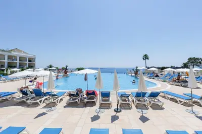 a group of chairs and umbrellas next to a swimming pool at Studio vue mer Cannes - Piscine - Tennis - Clim in Cannes