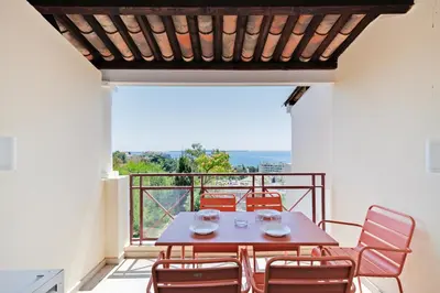 a table and chairs on a balcony with a view at Studio vue mer Cannes - Piscine - Tennis - Clim in Cannes